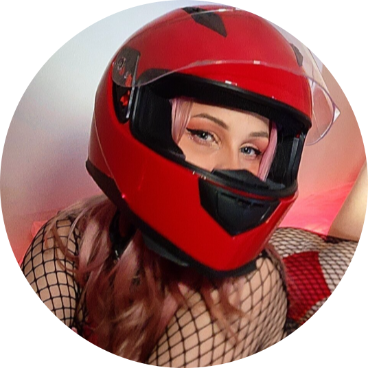 ash blonde girl in early 20s playing with her hair in front of white brick background